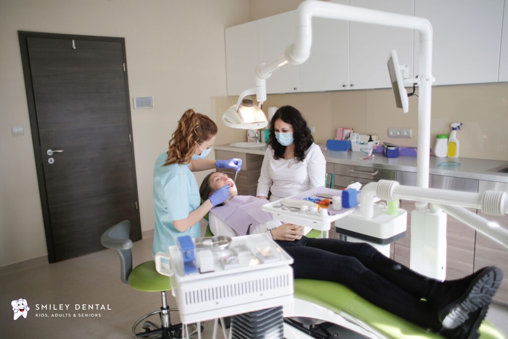 Dentist and dental assistant treating a patient during a same-day emergency dental appointment at Smiley Dental