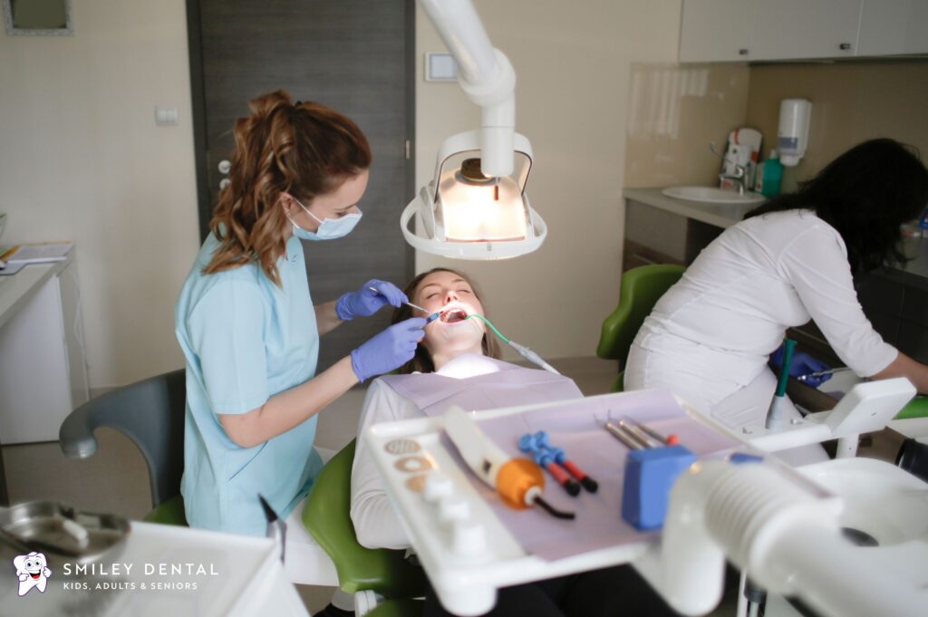 Dentist and assistant providing dental treatment to a patient in a Boston dental office