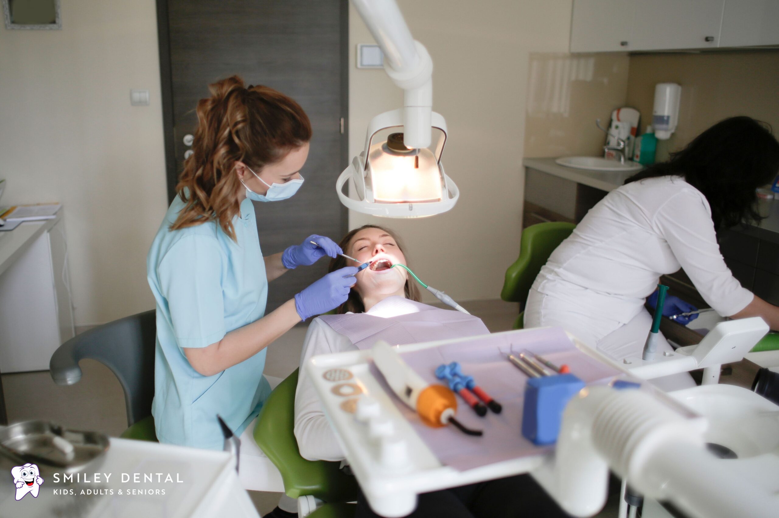 Dentist and assistant providing dental treatment to a patient in a Boston dental office