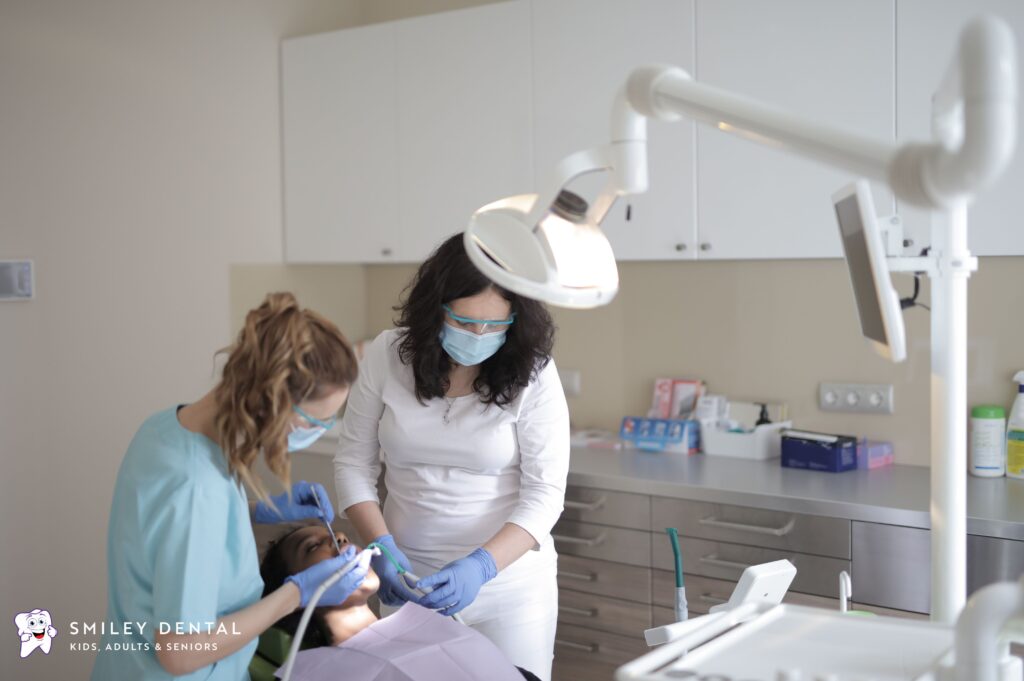 Dentist and dental assistant treating a patient in a modern Roslindale, Boston dental office