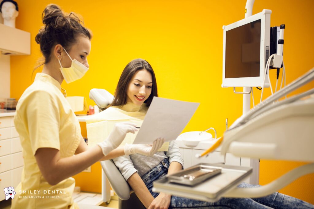 Dentist explaining MassHealth and Medicaid dental insurance options to a patient in a modern dental clinic