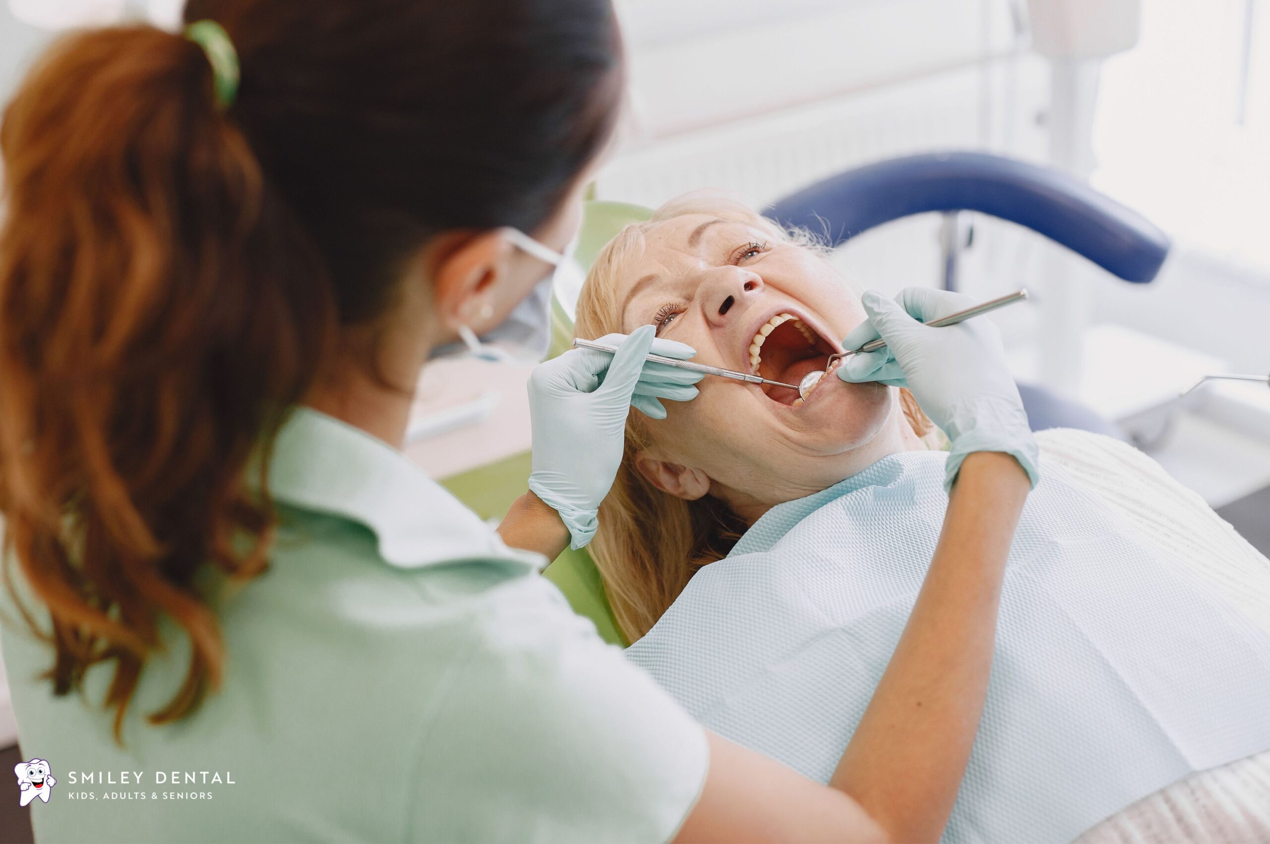 Dentist examining adult patient's teeth during a dental checkup covered under MassHealth dental benefits