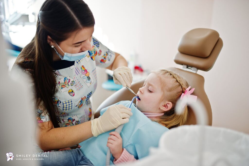 Dentist examining a young girl's teeth during a routine dental checkup